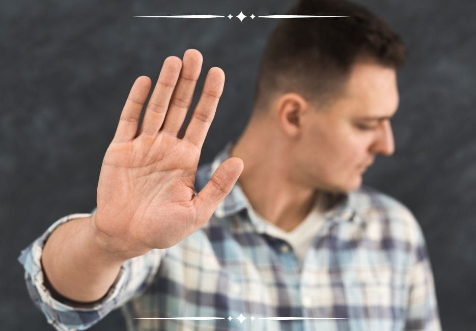 man holding his palm out and looking away, choosing not to engage