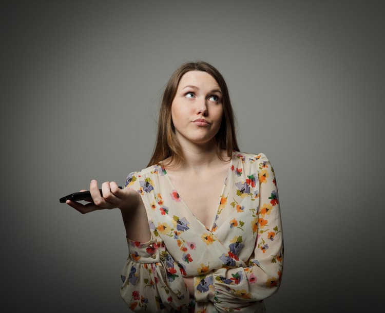 Woman with a cell phone rolling her eyes.