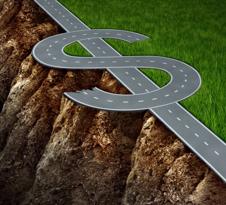 Road with a dollar sign separating green grass on one side and a financial cliff on the other.