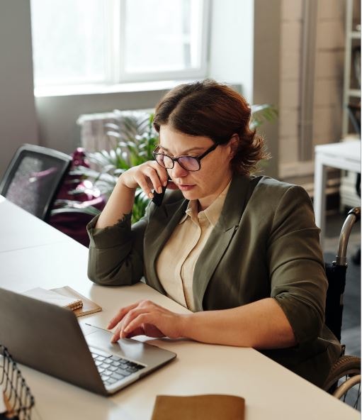 Woman in business suit sitting at a laptop attending virtual court.