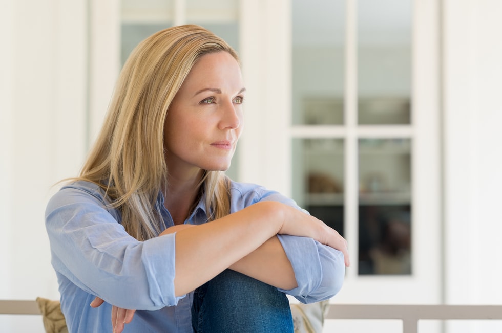 Beautiful blonde middle-aged woman in blue jeans looking hopeful