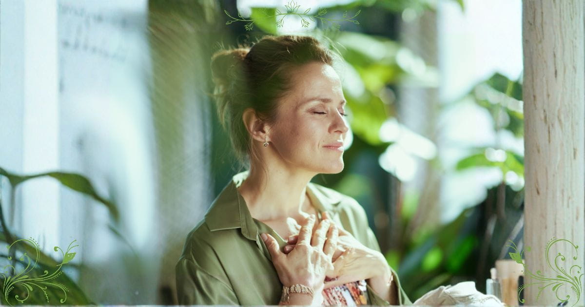 A woman placing a hand over chest, a serene smile on her face. Emotional wellbeing