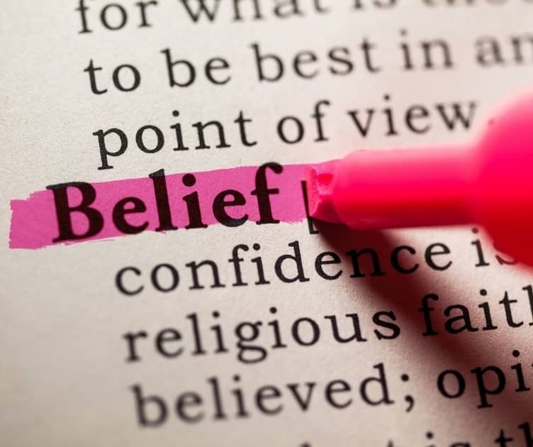 Definition of belief with close up of pink highlighter on the word belief.