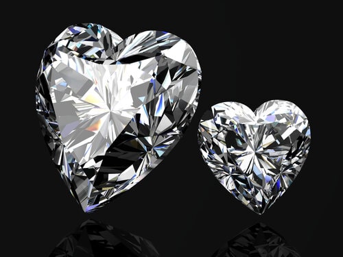 2 heart-shaped Diamonds on a black background. How to Sell Diamonds Online.