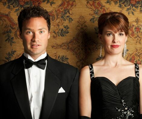 Man in a tuxedo and woman in a beuatiful dress on an awkward date.
