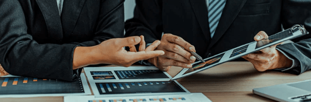 Close up of businessmen's hands going over financial reports.
