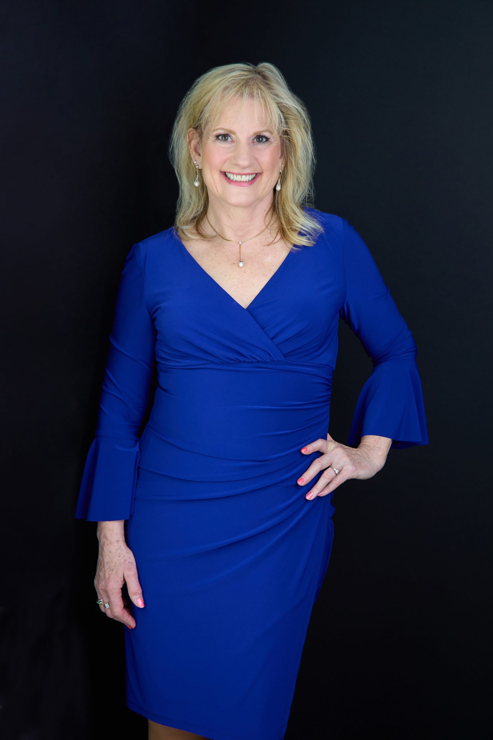 Karen Covy Divorce Coach and Lawyer in a blue dress against a black background