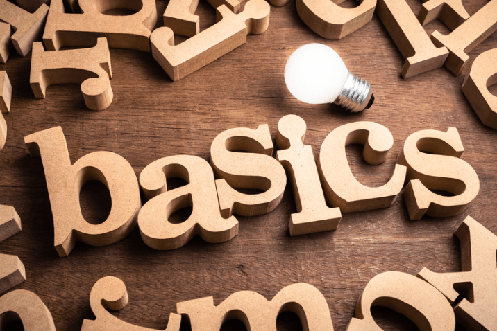 wooden letters that spell the word "basics" with a lightbulb over them.