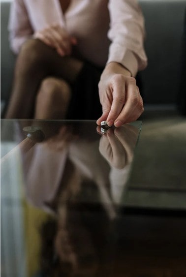 Woman about to take the "Ready for Divorce Quiz"  putting wedding ring on a table in front of her. 