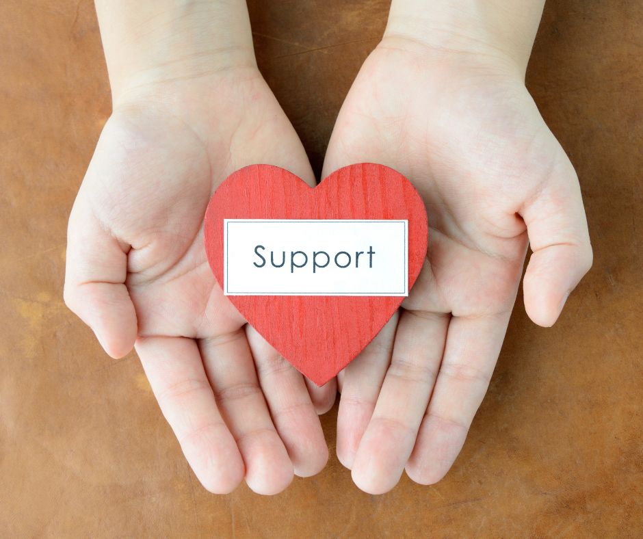 Divorce Support Two outstretched hands holding a red paper heart with teh word "support" on it signifying divorce support.
