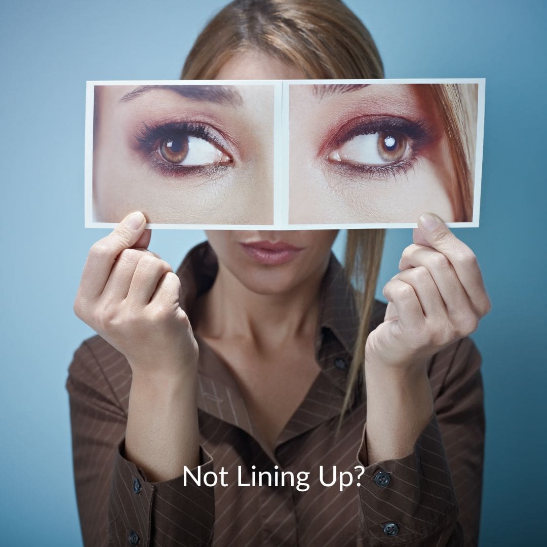 Not Lining Up Woman holding up picture of two eyes looking in opposite directions. Caption: Not LIned Up?