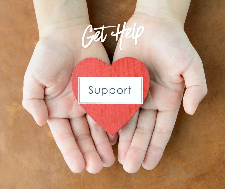 Get Help Divorce Support Two outstretched hands holding a red paper heart with teh word "support" on it signifying divorce support.