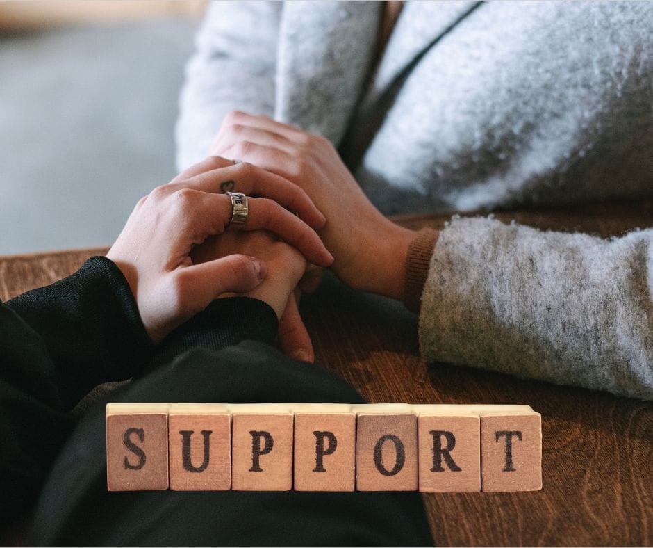 Woman holding another woman's hands. Shows support.