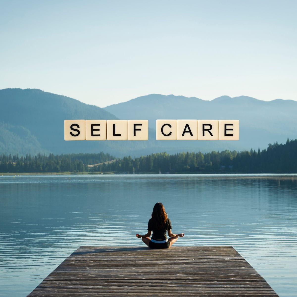 Woman meditating on a dock next to mountains and a lake withthe words "self care" above her.
