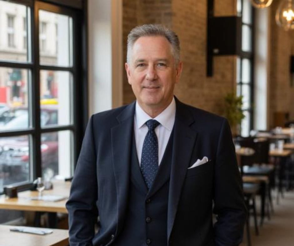 Testimonial Man 11 AI image of a confident senior executive man in a coffee shop looking at camera.