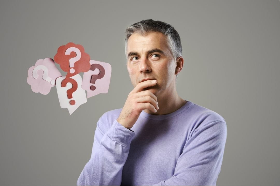 A man thinking, his hand under his chin. Question marks are next to him signifying he is trying to think about things