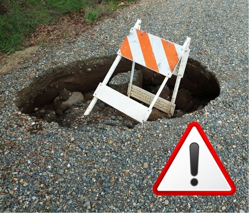 danger sign in front of a manhole