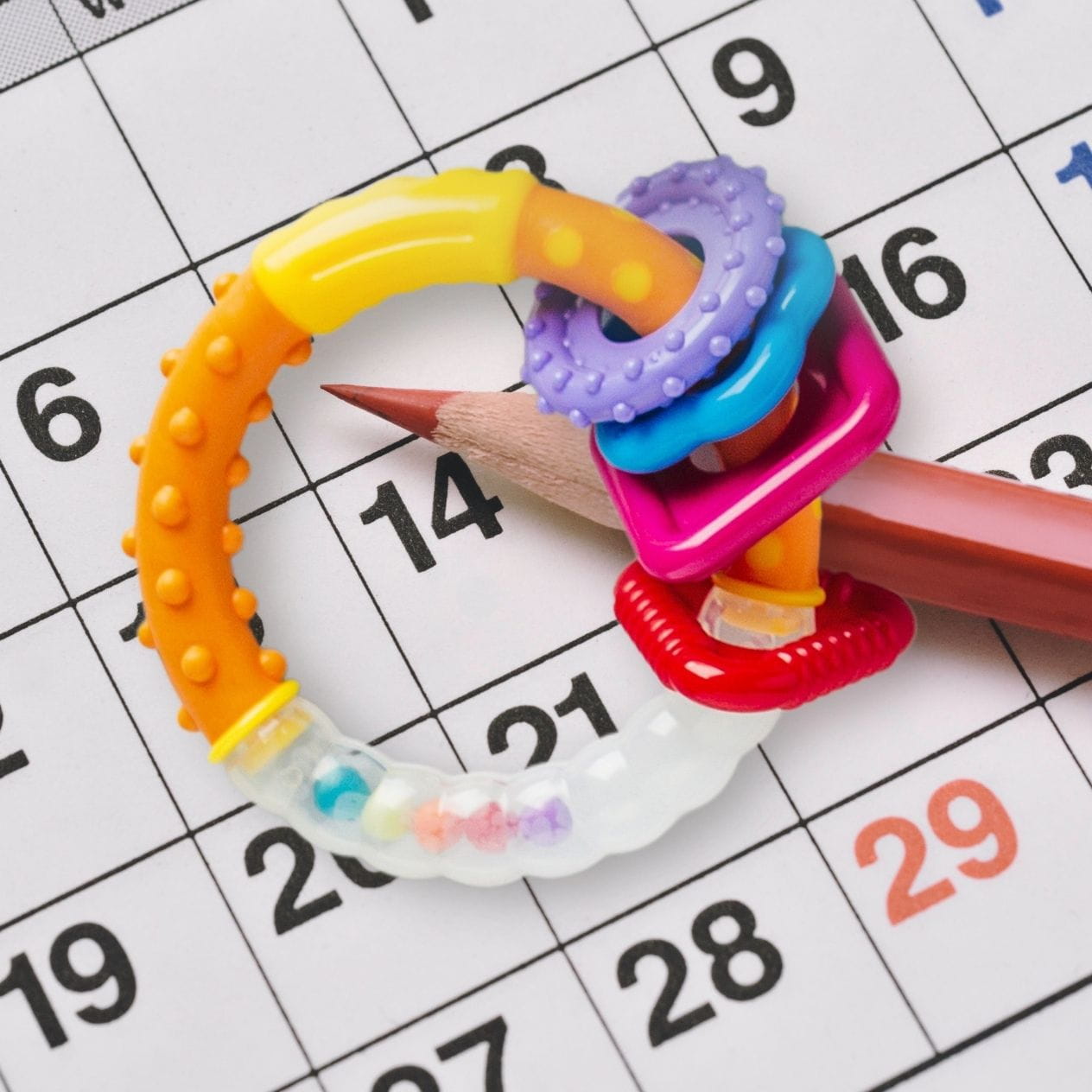 Co parenting schedule with pencil and teething ring.