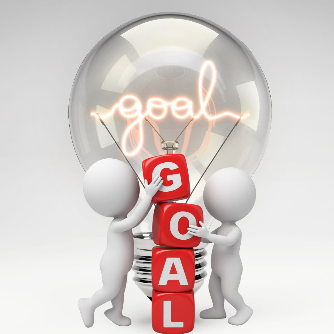 2 figures stacking dice that spell "Goal" in front of a lightbulb.