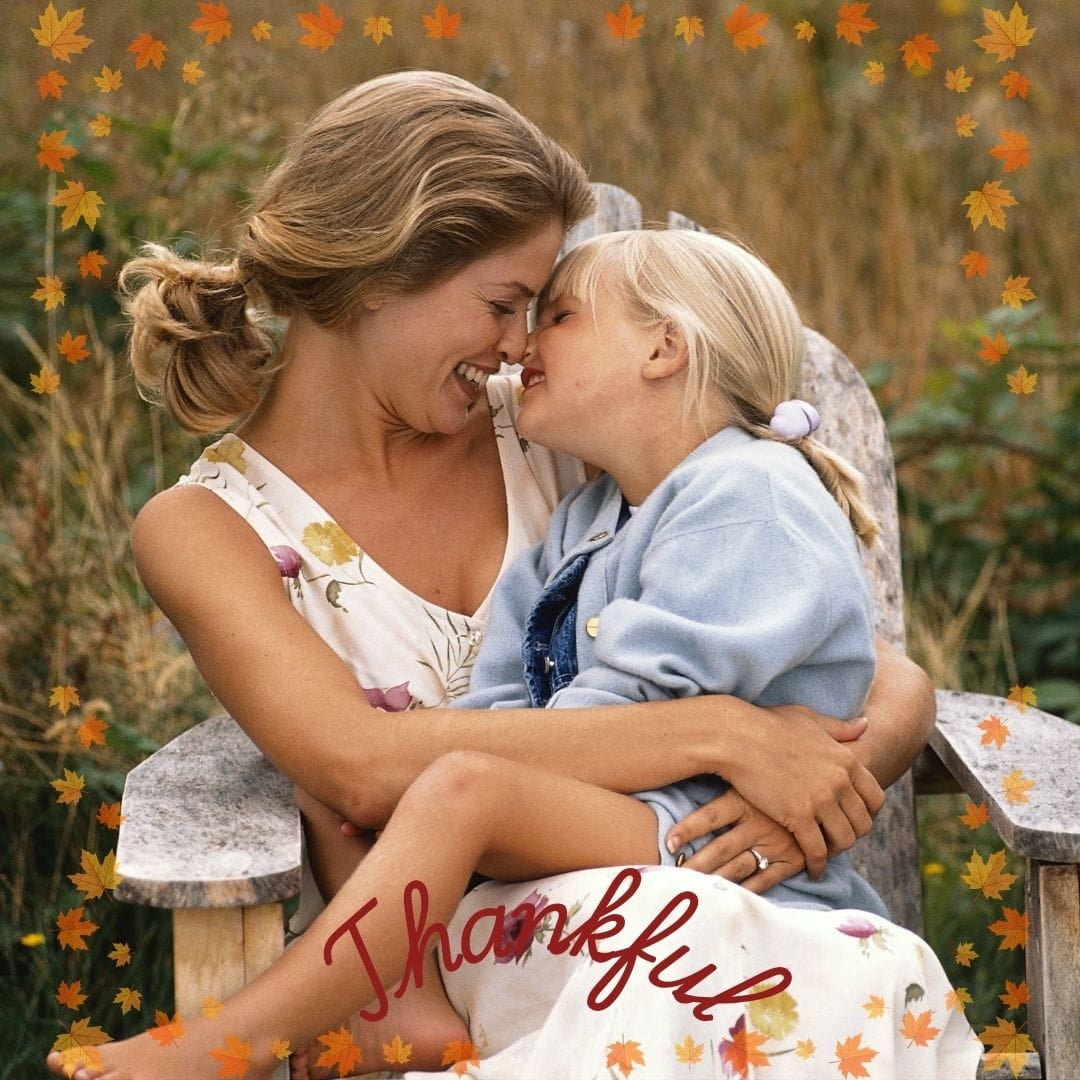 Mother and Child Happy mother and child sitting in a chair outside with the word "thankful".