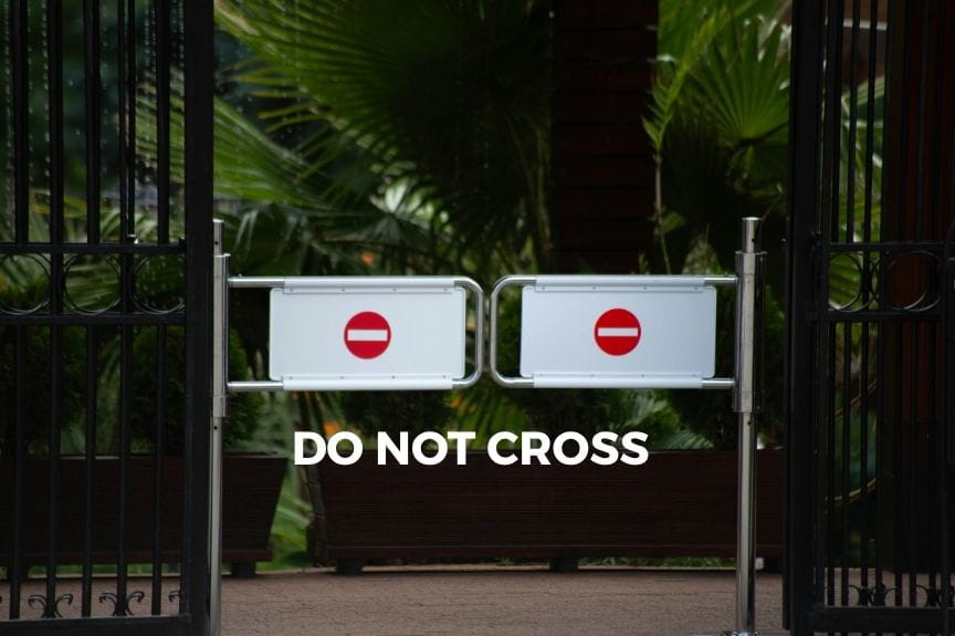 A gate with a sign that says do not cross. Boundaries